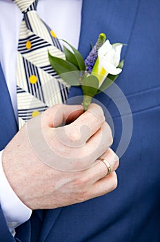 Wedding boutonniere of groom and groom`s hand