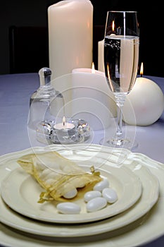 Wedding breakfast dining table setting with sugar almonds on fina china with champagne flute photo