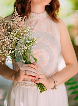 Wedding bridal bouquet of Gypsophila in the hands of the bride.