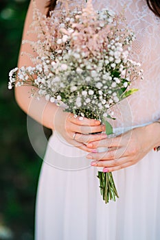 Wedding bridal bouquet of Gypsophila in the hands of the bride.