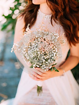 Wedding bridal bouquet of Gypsophila in the hands of the bride.