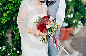 Wedding bridal bouquet of roses, celosia, Proteus in the hands o