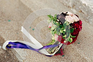 Wedding bridal bouquet of roses, celosia, Proteus on the rocks.