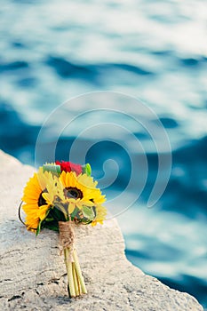 Wedding bridal bouquet of sunflowers on the dock near the sea. W