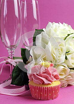 Wedding bridal bouquet of white roses on pink background with cupcake