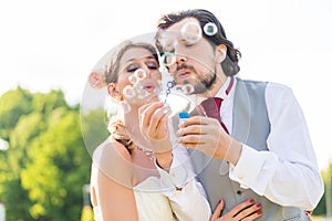 Wedding bride and groom blowing bubbles