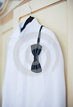 Wedding bright white shirt and black bow. Formal groom shirt with black bow-tie. Elegant white groom's shirt close up with bow tie