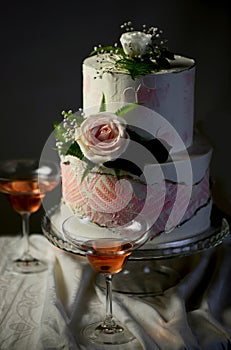 Festive wedding bunk cake decorated with fresh flowers on a dark background