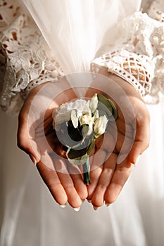 Wedding buttonhole in bridal hands close up