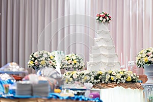Wedding cake and beautiful flowers decorations in wedding ceremony.