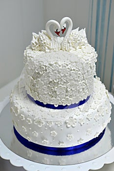White wedding cake with cream decorated with swans