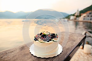 Wedding cake of figs, cherries and berries with a white cream. O