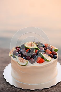 Wedding cake of figs, cherries and berries with a white cream. O