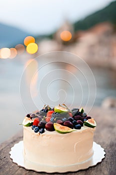 Wedding cake of figs, cherries and berries with a white cream. O