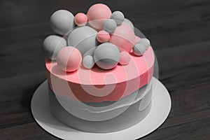 Wedding cake with pink elements made from pastry mastic on a gray background. Sugar balls beautiful decor for decorating cakes.