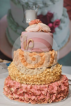 Wedding cake with pink frosting and a flowers on top