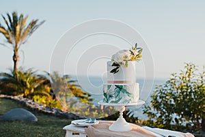 Wedding cake on table near sea