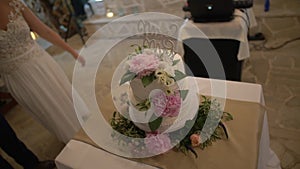 wedding cake with white cream, decorated with flowers of peonies and lisianthus