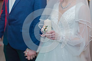 The wedding candle in the hands of the bride and groom. the candle is the family hearth at the wedding. Candle in hand