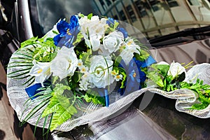 Wedding car decorated with bouquets of white roses