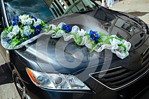 Wedding car decorated with bouquets of white roses