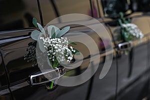 Wedding car decorated with flowers on the door