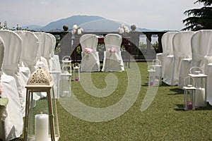 Wedding ceremony outdoor set: line of white chairs with desk and chair for the married and  the officer