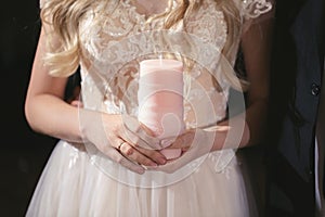 Wedding ceremony, paraphernalia, the bride and groom hold a large candle in their hand.