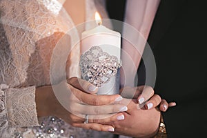 Wedding ceremony, paraphernalia, the bride and groom hold a large candle in their hand.