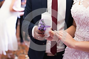 Wedding ceremony, paraphernalia, the bride and groom hold a large candle in their hand.