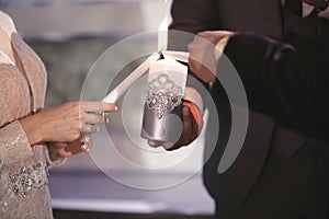 Wedding ceremony, paraphernalia, the bride and groom hold a large candle in their hand.