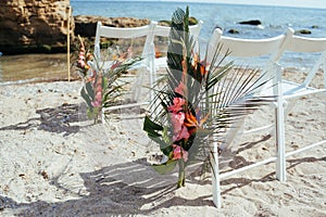 Wedding ceremony setup on white sand beach.