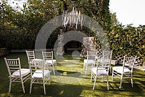 Wedding ceremony with transparent chairs and arch with flowers