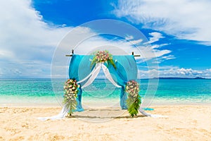 Wedding ceremony on a tropical beach in blue. Arch decorated wit