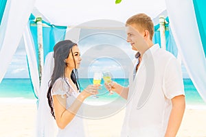 Wedding ceremony on a tropical beach in blue. Happy groom and br