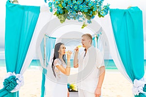 Wedding ceremony on a tropical beach in blue. Happy groom and br