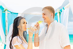 Wedding ceremony on a tropical beach in blue. Happy groom and br