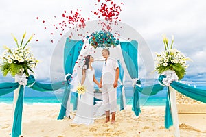 Wedding ceremony on a tropical beach in blue. Happy groom and br