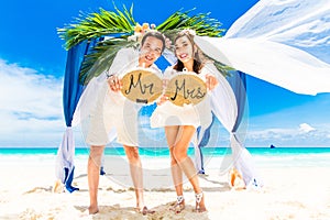 Wedding ceremony on a tropical beach in blue. Happy groom and br