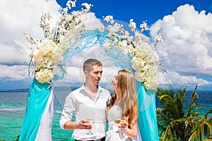 Wedding ceremony on a tropical beach in blue. Happy groom and br