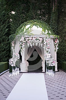 Wedding ceremony. Very beautiful and stylish wedding arch, decorated with various artificial flowers and mirror