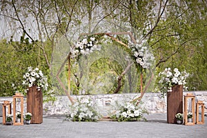 Wedding ceremony. Very beautiful and stylish wedding arch, decorated with various fresh flowers, standing in the garden.