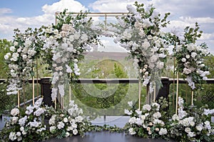 Wedding ceremony. Very beautiful and stylish wedding arch, decorated with various fresh flowers, standing in the garden.