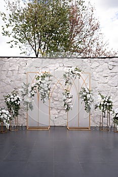 Wedding ceremony. Very beautiful and stylish wedding arch, decorated with various fresh flowers, standing in the garden.