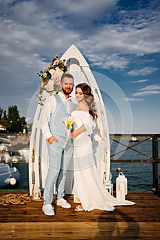 wedding ceremony by water on dock. bride and groom.