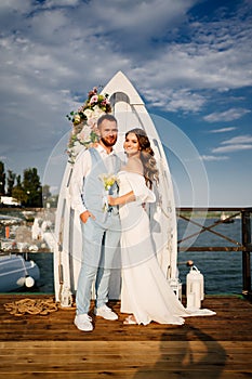 wedding ceremony by water on dock. bride and groom.