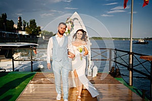 wedding ceremony by water on dock. bride and groom.