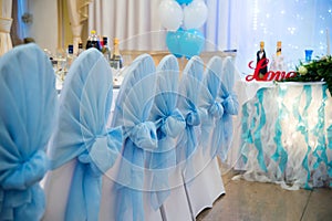 Wedding chairs with blue bows.