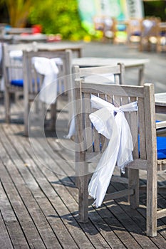 Wedding chairs decorated with white bows at