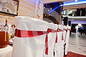 Wedding chairs for guests with red ribbons.